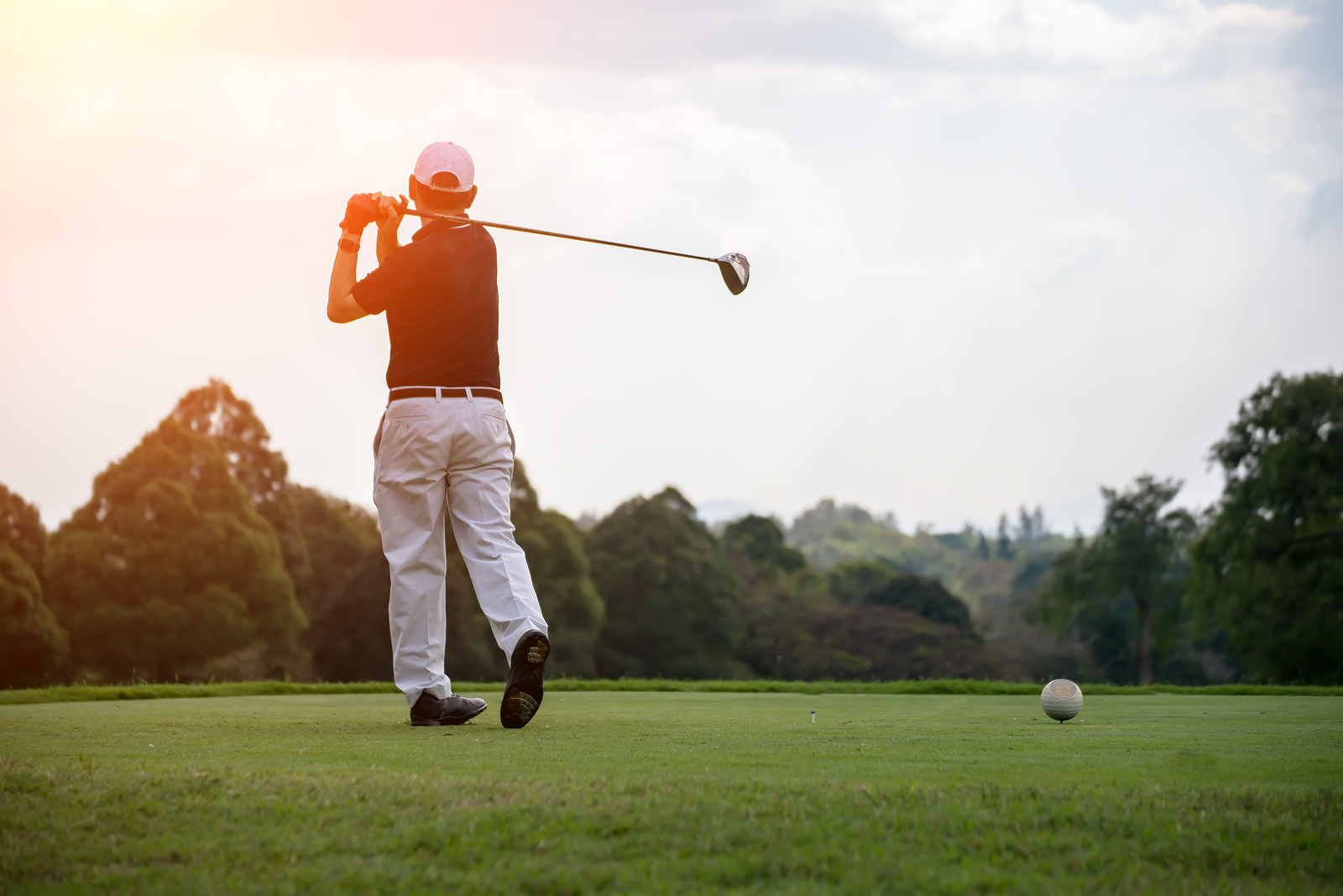 Golfers men player golf hit swing shot on course sunset.